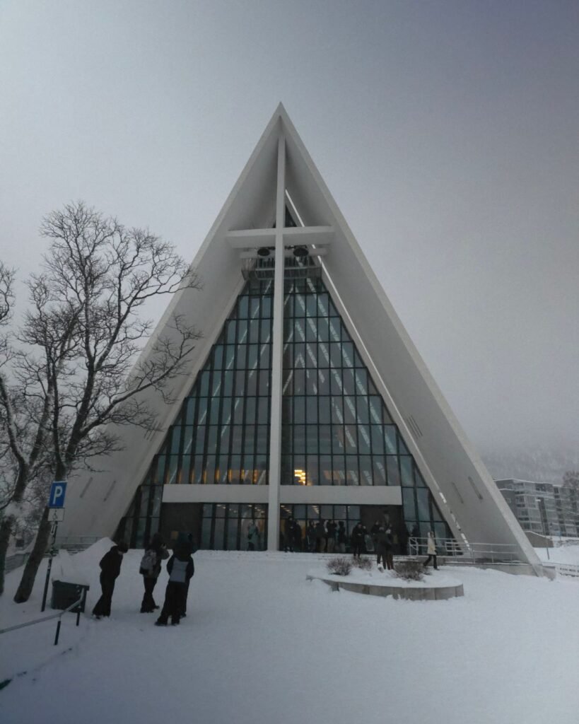 The Arctic Cathedral in Tromsø, Norway, showcasing its modern architecture against the snowy landscape.