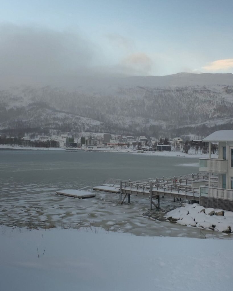 A tranquil view of Kaldfjord with  frozen water and rugged mountains and fjords, captured during a scenic walk in Tromsø.