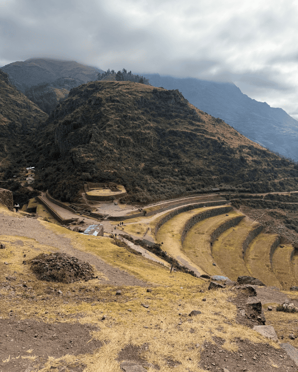 Inca terraces and ruins below hazy mountains at the Pisac archaeological site